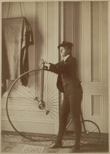 Frances Benjamin Johnston, Self-portrait by Johnston, Dressed as a Man, Sporting a Fake Mustache and Holding a Bicycle, c 1890